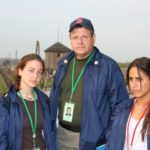 Image of Irv Kempner with two MOTL teenager girl marchers witness the Nazi guard towers and electrified fences of Majdanek death camp near Lublin.