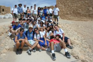 Image of March of the Living teenagers rest on top of Masada