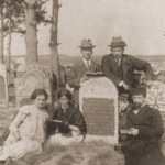 Image of Family gathered at a tombstone in the Wloszczowa