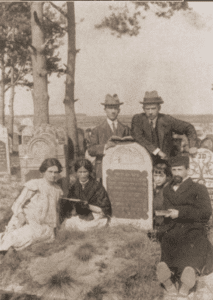 Image of Family gathered at a tombstone in the Wloszczowa
