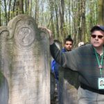 Image of Irv at Warsaw Cemetery headstones of his great grandparents.